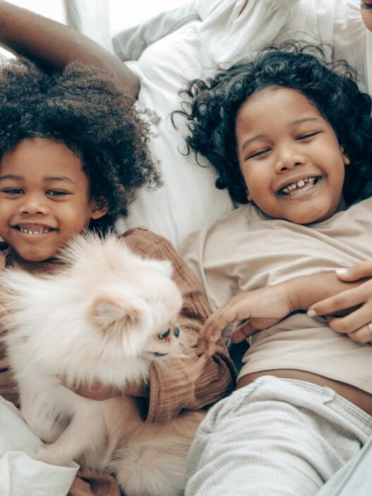 Happy family bonding time with kids and a Pomeranian dog in cozy home setting.