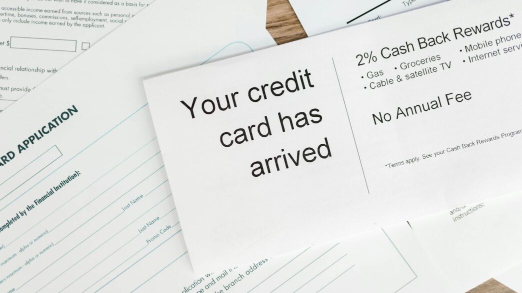 Close-up of a letter announcing the arrival of a credit card amidst financial documents.