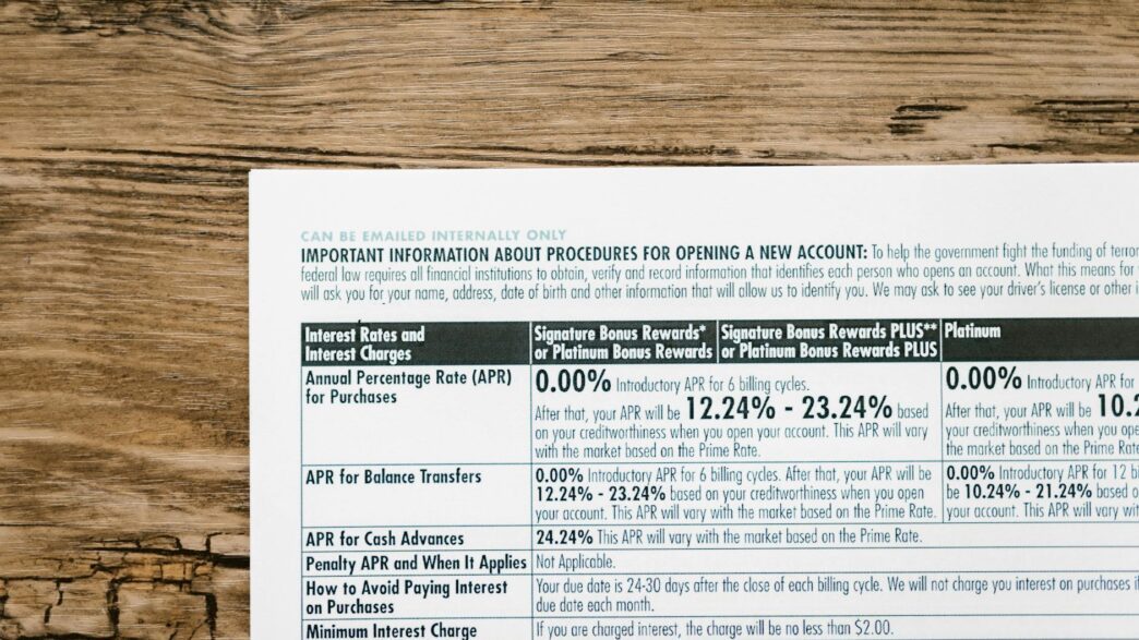 A detailed financial document listing interest rates on a textured wooden table.