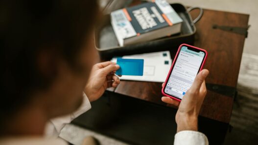 Person making an online payment using a smartphone and credit card indoors.