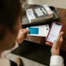 Person making an online payment using a smartphone and credit card indoors.