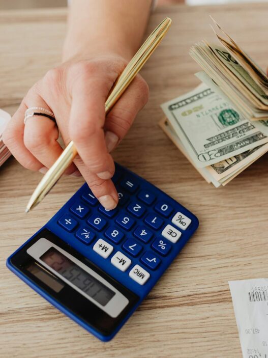 A person planning their monthly budget with a calculator and notebook