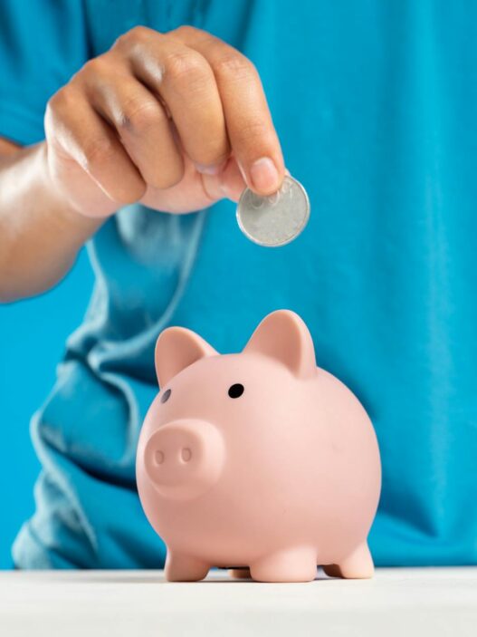 Stacked coins and a savings jar representing a CD ladder strategy