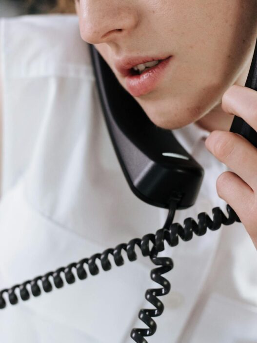 Person on a phone call reviewing a paper bill at a desk, illustrating negotiating lower monthly bills