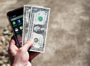 Person holding a smartphone reviewing their mobile phone bill