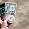 Person holding a smartphone reviewing their mobile phone bill