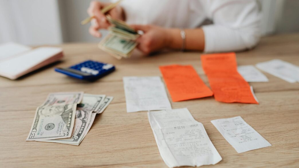 Stack of US cash next to a flashlight and storm preparation supplies, illustrating a hurricane season emergency cash kit