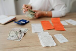 Stack of US cash next to a flashlight and storm preparation supplies, illustrating a hurricane season emergency cash kit