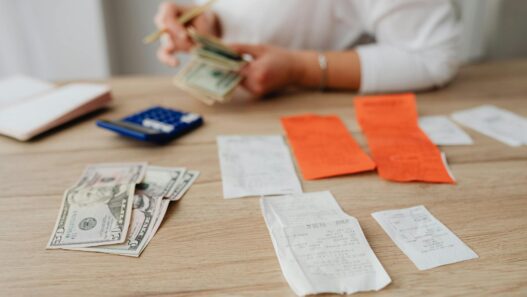 Stack of US cash next to a flashlight and storm preparation supplies, illustrating a hurricane season emergency cash kit