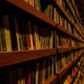 Rows of books on public library shelves, illustrating how a free library card unlocks streaming, museum passes, and learning subscriptions worth hundreds of dollars a year