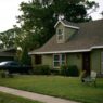 Suburban home with well-maintained roof and landscaping, illustrating homeowners insurance premium and storm preparation savings