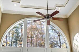 A bright living room with a ceiling fan and natural light, illustrating practical ways to lower summer cooling and energy costs.