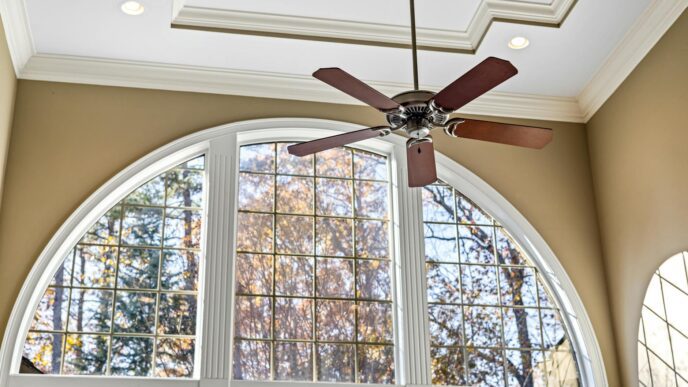 A bright living room with a ceiling fan and natural light, illustrating practical ways to lower summer cooling and energy costs.
