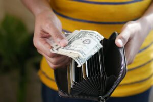 A wallet next to coins and a notebook representing a no-spend savings challenge