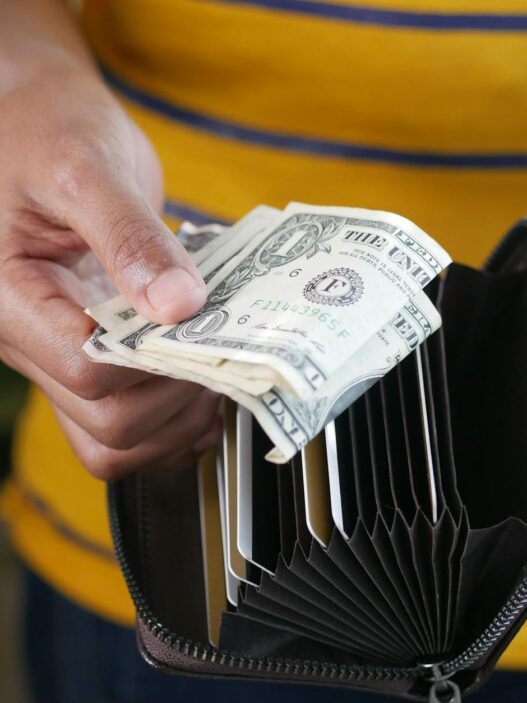 A wallet next to coins and a notebook representing a no-spend savings challenge