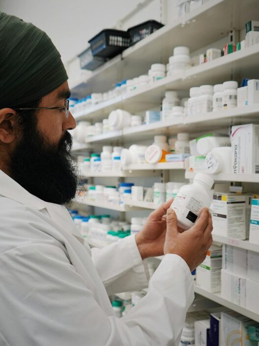 Pharmacist handing a prescription bag across a pharmacy counter, illustrating prescription drug savings