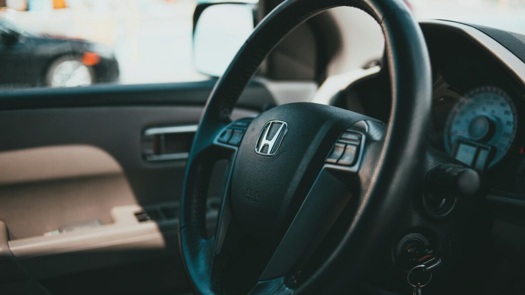 Car keys resting on a contract and steering wheel, illustrating the decision to refinance an auto loan in 2026