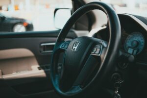 Car keys resting on a contract and steering wheel, illustrating the decision to refinance an auto loan in 2026
