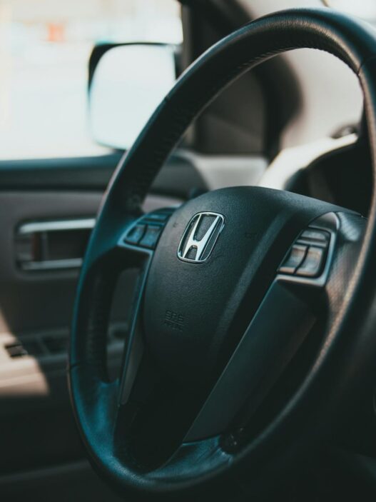 Car keys resting on a contract and steering wheel, illustrating the decision to refinance an auto loan in 2026