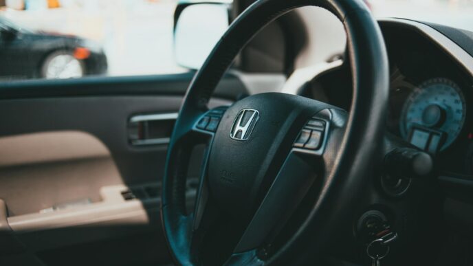 Car keys resting on a contract and steering wheel, illustrating the decision to refinance an auto loan in 2026
