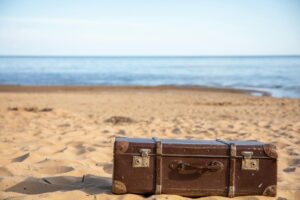 Suitcase and travel essentials packed for a summer vacation, illustrating saving for a trip