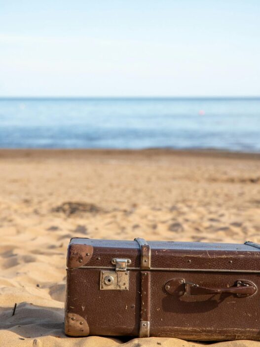 Suitcase and travel essentials packed for a summer vacation, illustrating saving for a trip