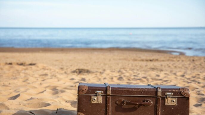 Suitcase and travel essentials packed for a summer vacation, illustrating saving for a trip