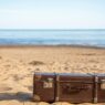 Suitcase and travel essentials packed for a summer vacation, illustrating saving for a trip