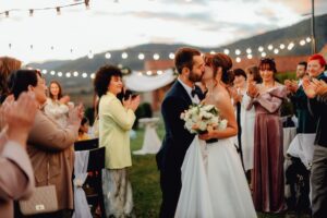 Guests celebrating at an outdoor summer wedding reception, illustrating how to attend weddings on a budget