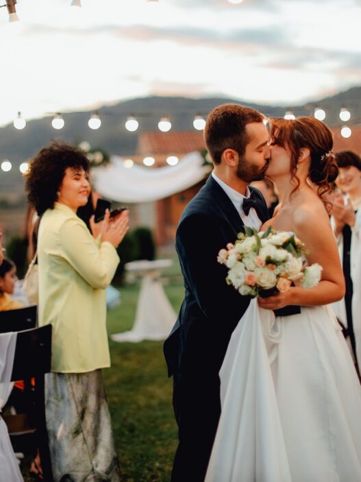 Guests celebrating at an outdoor summer wedding reception, illustrating how to attend weddings on a budget