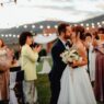 Guests celebrating at an outdoor summer wedding reception, illustrating how to attend weddings on a budget
