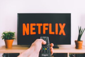 Person holding a remote in front of a streaming TV menu