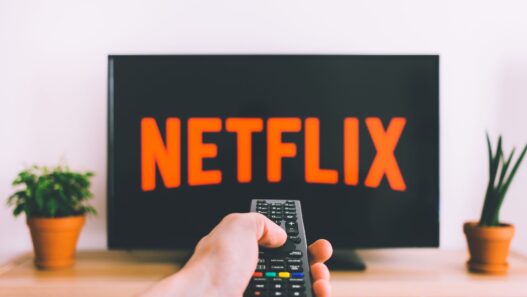 Person holding a remote in front of a streaming TV menu
