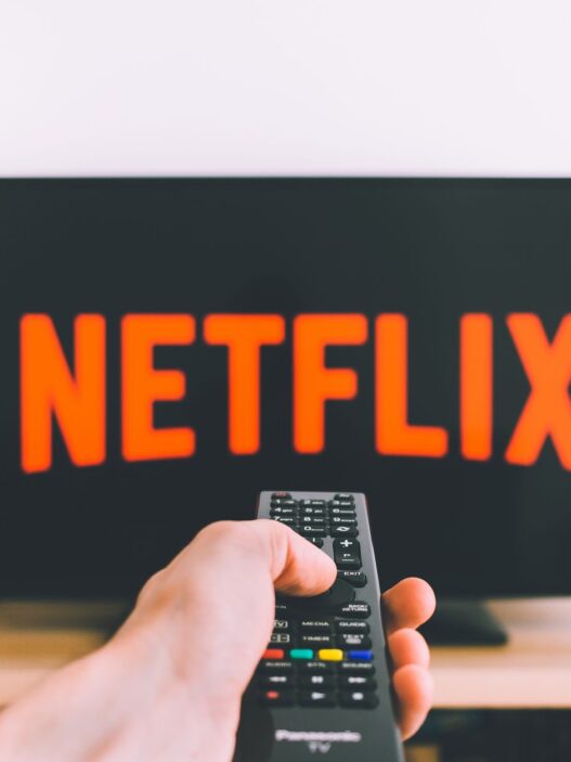 Person holding a remote in front of a streaming TV menu