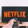 Person holding a remote in front of a streaming TV menu