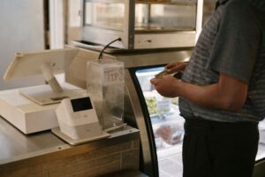 Shopper at a store checkout counter deciding on a purchase