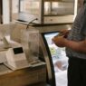 Shopper at a store checkout counter deciding on a purchase