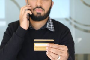 Person on the phone holding a credit card while negotiating a lower interest rate