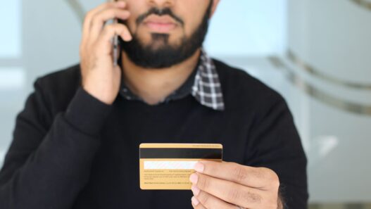Person on the phone holding a credit card while negotiating a lower interest rate