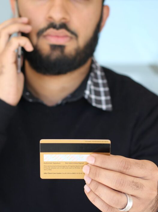 Person on the phone holding a credit card while negotiating a lower interest rate