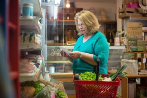 Fresh groceries and a shopping list on a kitchen counter representing weekly meal planning to save money