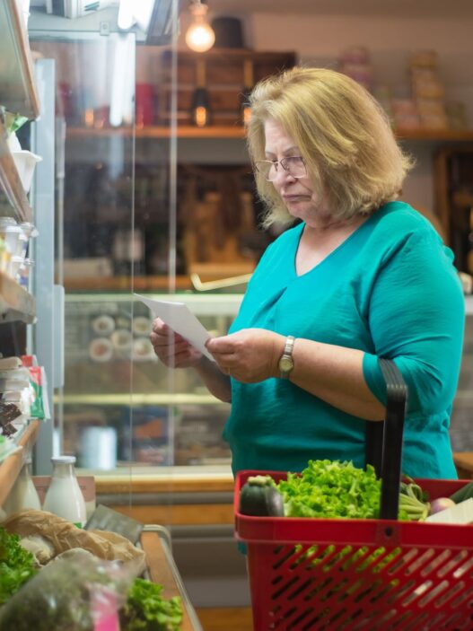 Fresh groceries and a shopping list on a kitchen counter representing weekly meal planning to save money