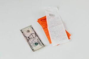 A shopper holding a receipt at a store checkout, illustrating how to request a price adjustment refund when a price drops