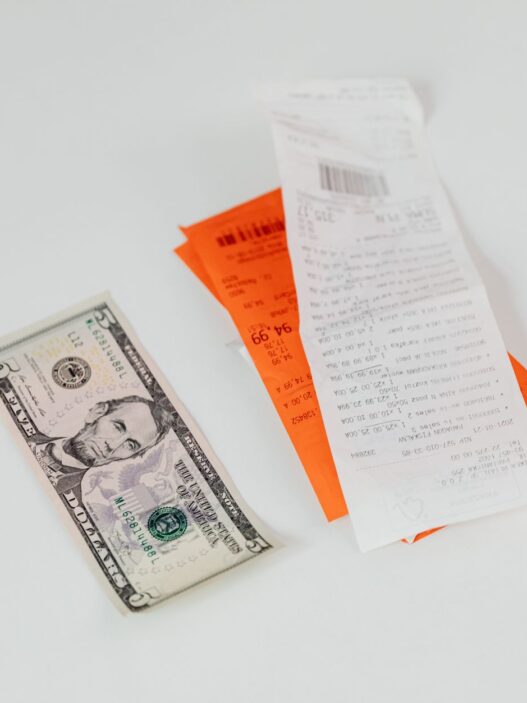 A shopper holding a receipt at a store checkout, illustrating how to request a price adjustment refund when a price drops