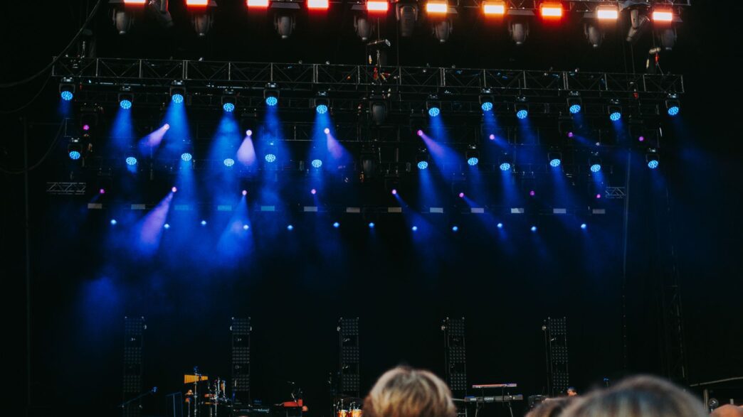 Crowd at an outdoor summer concert with stage lights