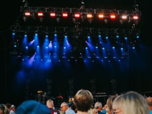 Crowd at an outdoor summer concert with stage lights