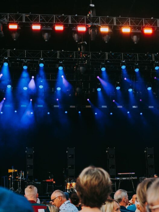 Crowd at an outdoor summer concert with stage lights