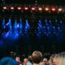 Crowd at an outdoor summer concert with stage lights