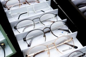 Rows of prescription eyeglasses frames on display in an optical shop