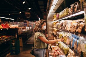 Grocery store shelves stocked with products representing store-brand vs name-brand savings